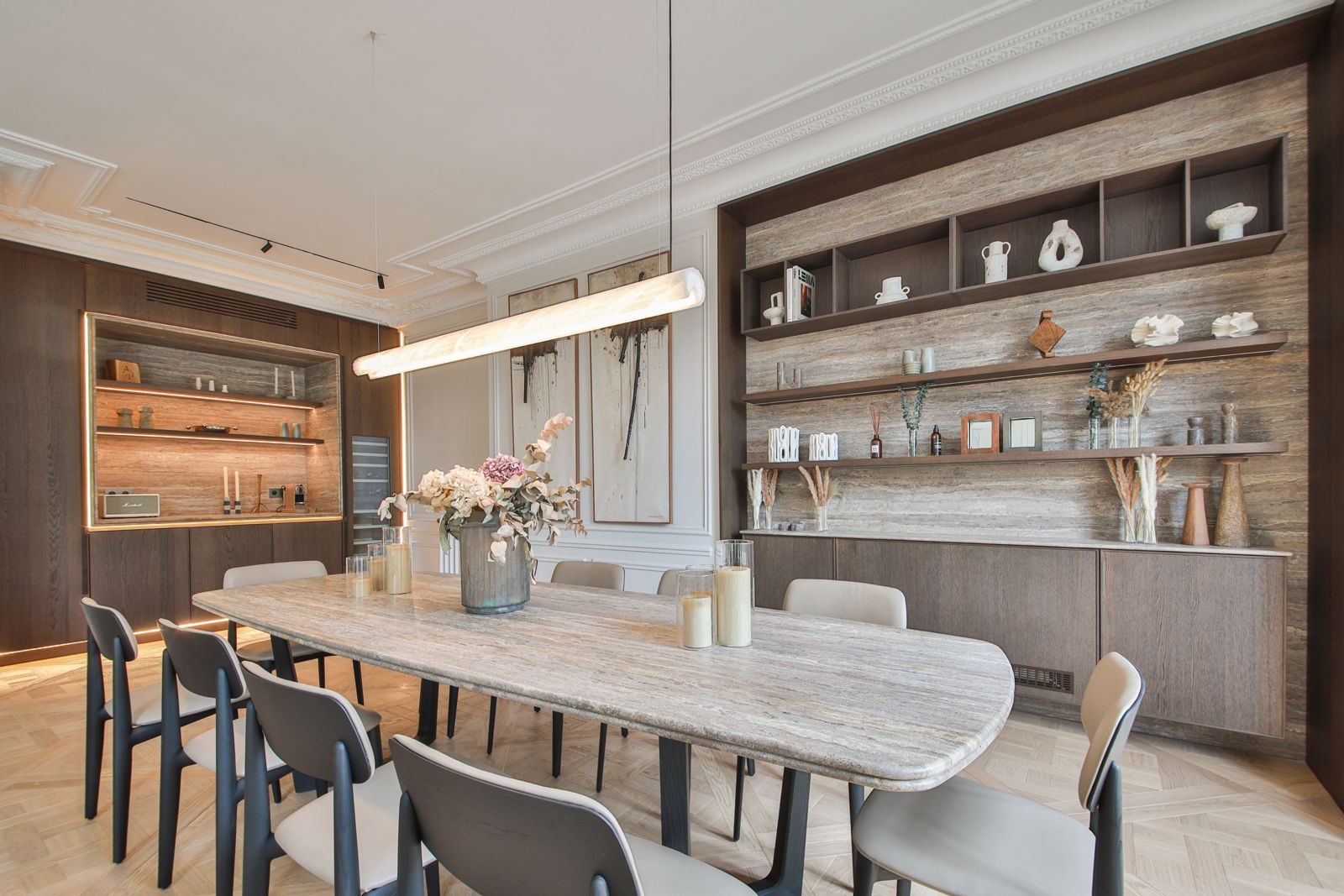 Travertine dining table for ten under an alabaster pendant light, in a renovated Haussmann apartment in Paris